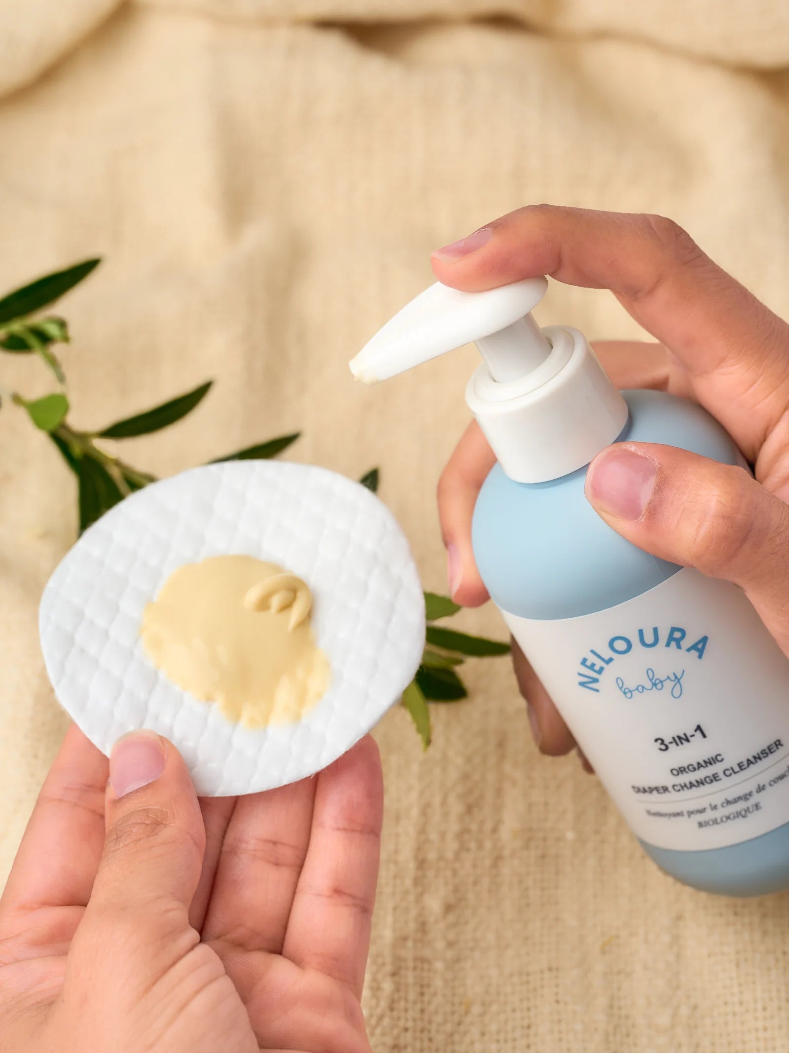 Neloura cleanser being used with a pad on a textured changing surface.