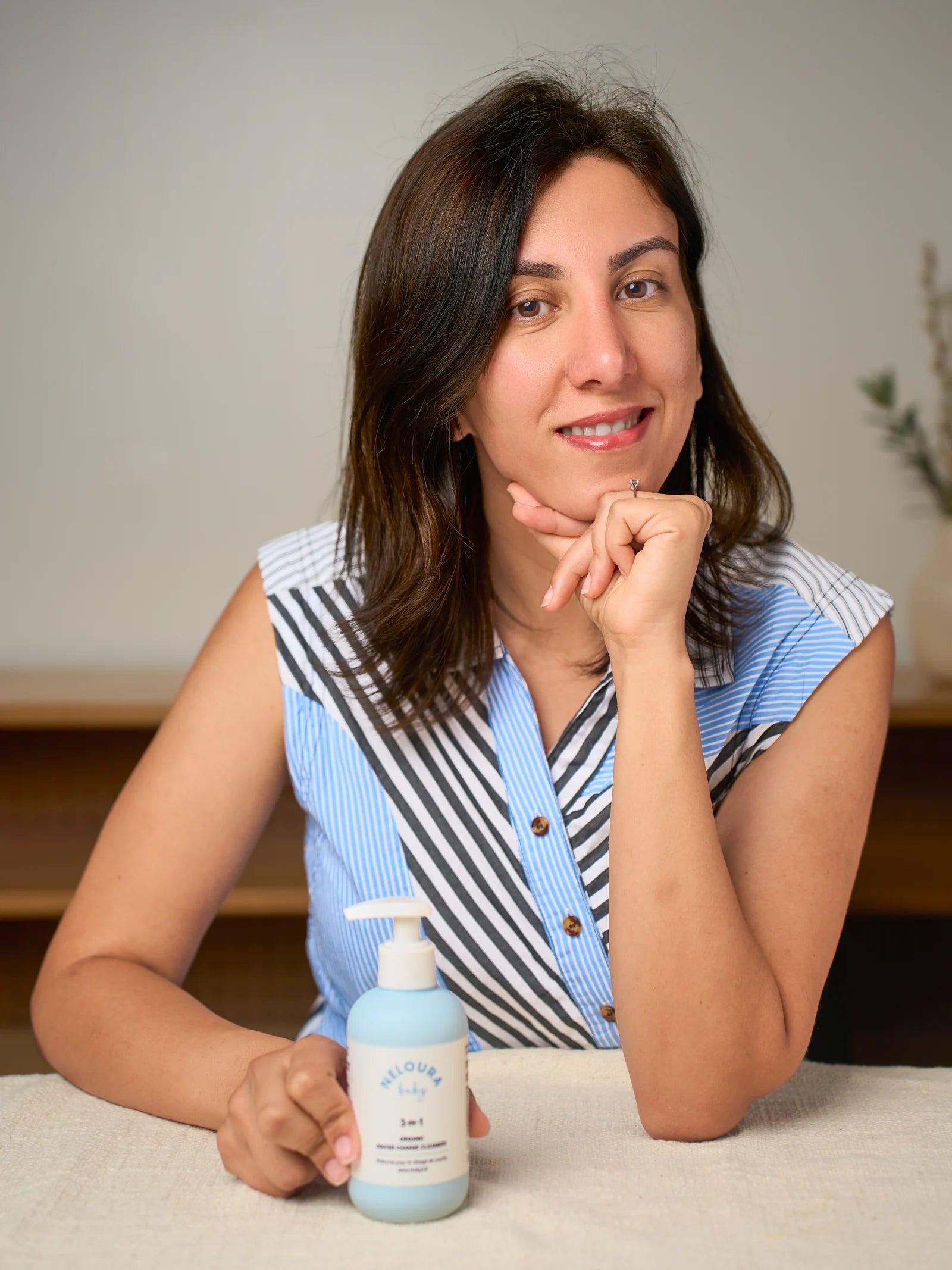 Ana, founder of Neloura, holding the cleanser