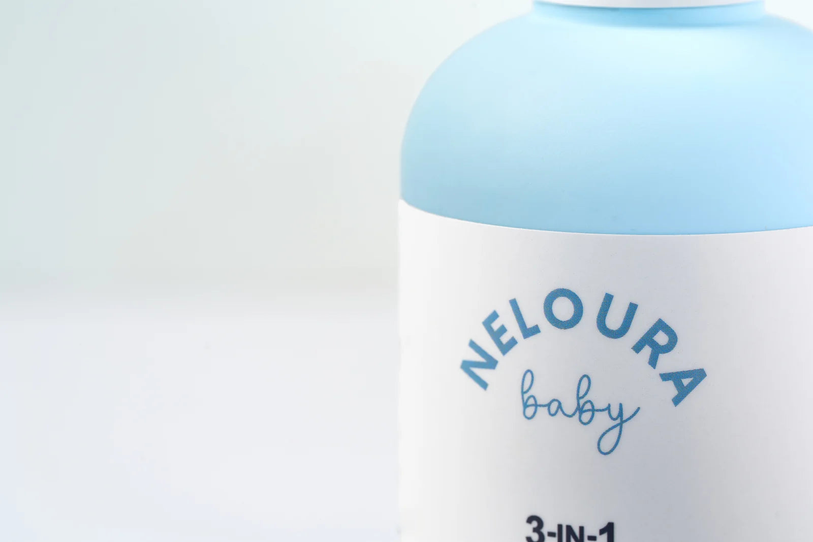 A close-up of the Neloura logo and the powder-blue bottle.