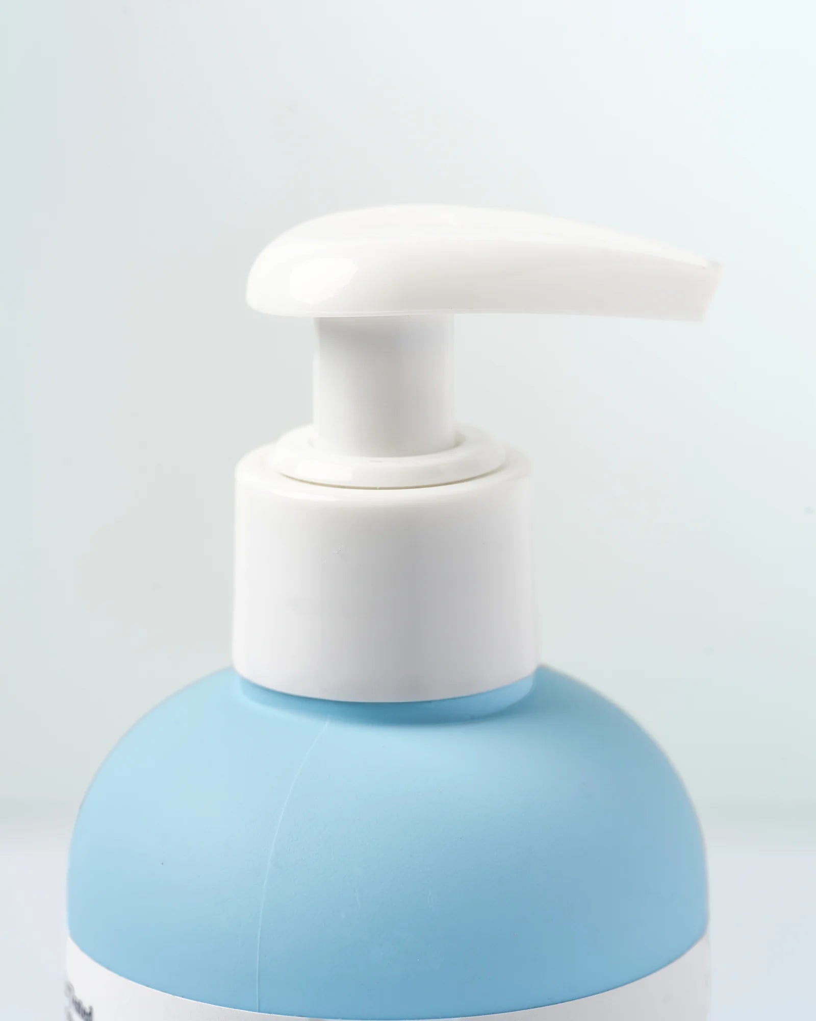 Close detail of the white pump and powder-blue Neloura bottle.